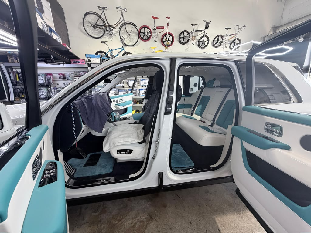 Asientos y tapicería de puertas blancos y turquesa de Rolls-Royce dentro del taller